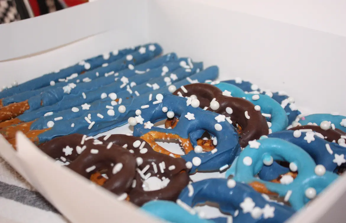 Close-up of blue and chocolate pretzels with snowflake sprinkles